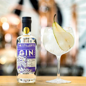 The Stillery's Most Floral Gin: bottle next to a balloon glass of gin and tonic with a pear slice